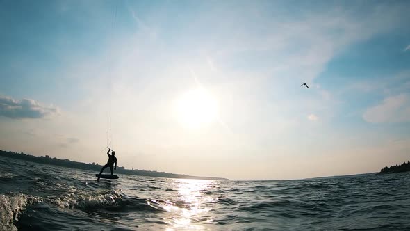 A Man Is Kitesurfing Along the Riverbank