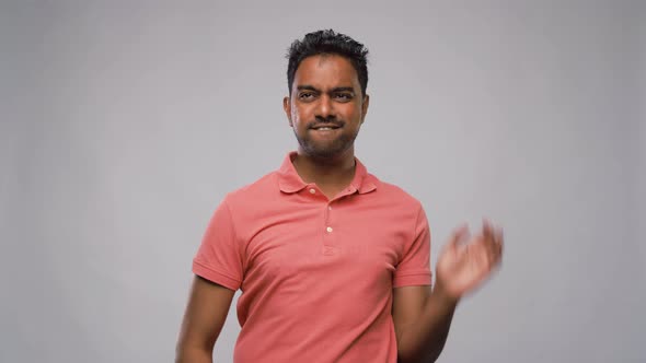 Young Indian Man Dancing Over Grey Background