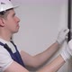 Builder Worker Makes Repairs Hanging Picture or Photo in Frame on Wall - VideoHive Item for Sale