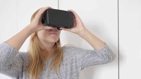 Blonde woman in white space trying virtual reality glasses  4K 2160p 30fps UltraHD footage - Blond f