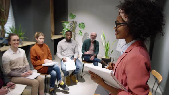 Afro-American Female Business Coach Giving Lecture to Team of Employees