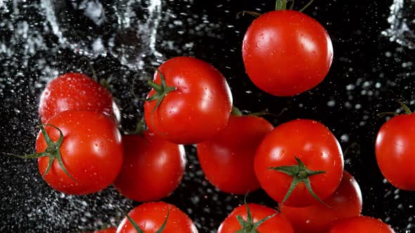Super Slow Motion Shot of Flying Fresh Tomatoes and Water Side Splash at 1000 Fps