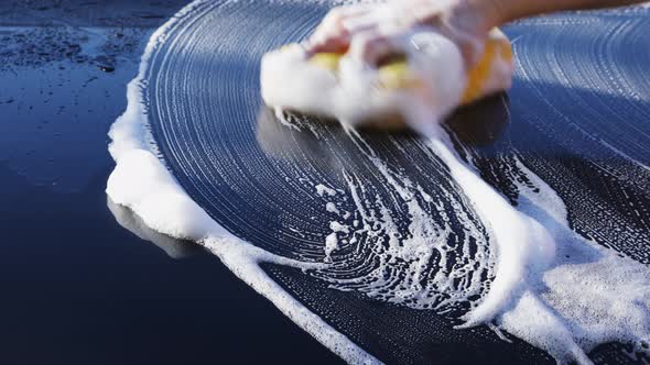 Washing car with sponge and shampoo