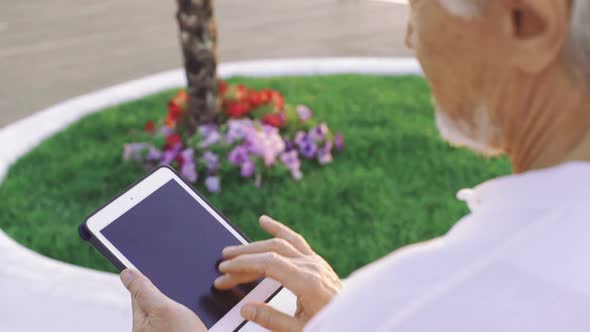 Portrait of Retirement Handsome Senior Man Using Tablet Computer on Seafront Close Up