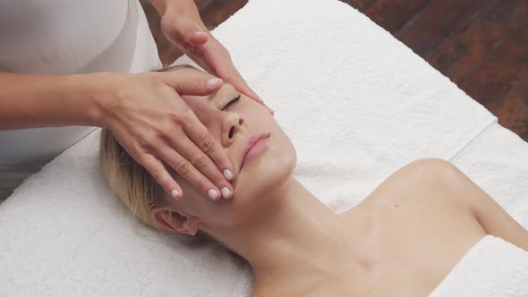 Young, healthy and beautiful woman gets massage therapy in the spa salon.