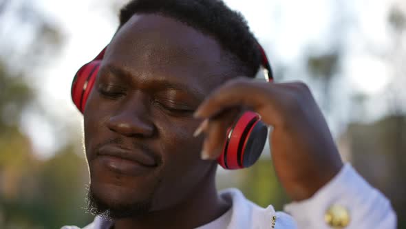 Closeup Portrait of Joyful Young African American Man in Headphones Listening to Music Dancing in