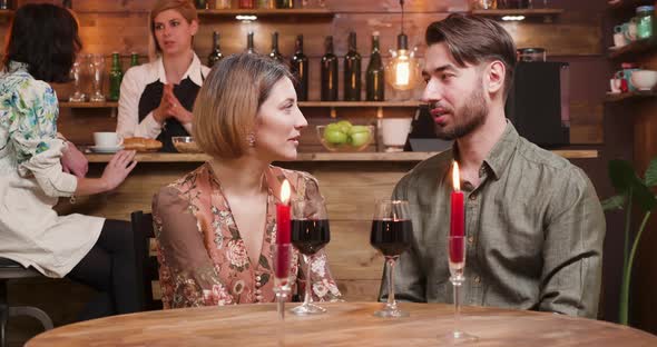 A Young Man and a Woman on a Date Drinking Wine and Laughing