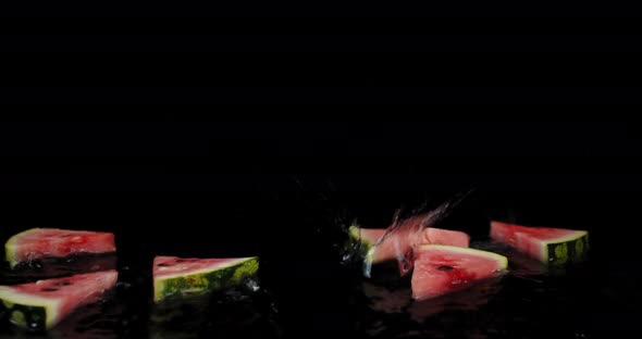 Pieces of Watermelon Fall on the Table with Water Spray. 