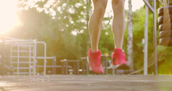 Professional Athlete Wearing Red Sneakers Jumping Rope on Sports Ground in City Park