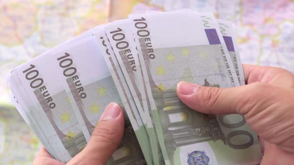 Man holding euro paper currency and counting 100 euro banknotes