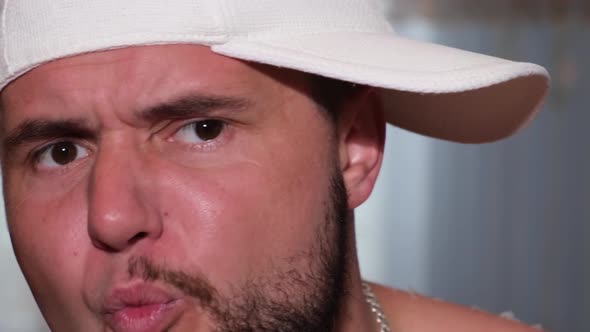 A Young Man Reads a Rap He is in a White Cap and Shows Strange Facial Expressions