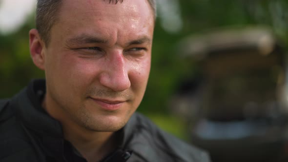 Gentleman in Jacket Closes Eyes Partly on Blurred Background