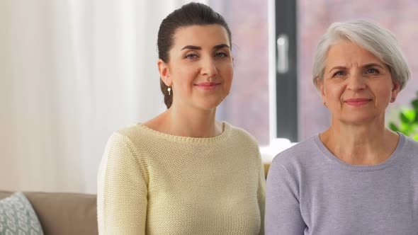 Senior Mother with Adult Daughter Hugging at Home