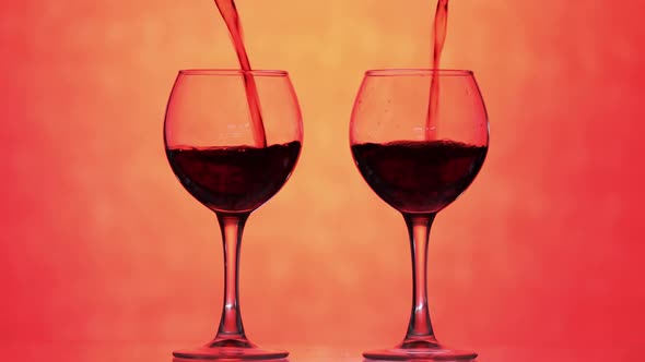 Rose Wine. Red Wine Pour in Two Wine Glasses Over Orange Background