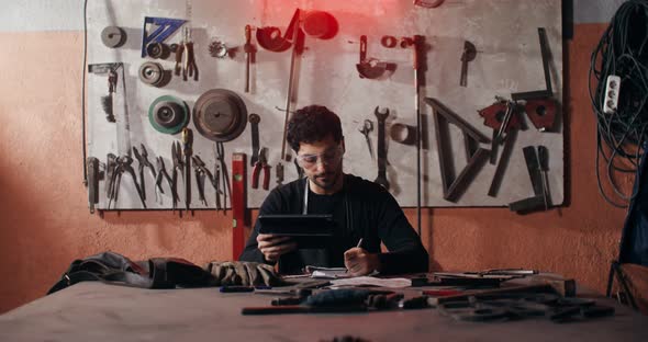 A Blacksmith Uses a Tablet to Create a Sketch of a Future Product