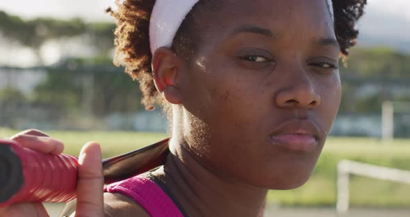 Video of african american female tennis player holding racket and looking at camera
