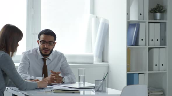 Middle Eastern Businessman Talking with Female Employee in Office