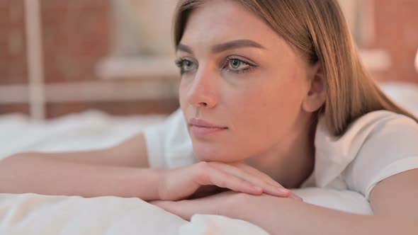 Close Up of Young Woman Looking Away and Thinking in Bed