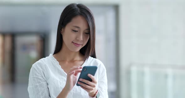 Woman look at the cellphone in the hall