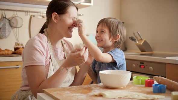 Happy Laughing Boy with Playing with Mother While Cooking and Throwing Flour