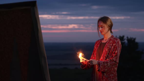 Young Artist Lights Piece Of Paper And Throws It At Her Painting.