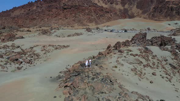 Tenerife, Lunar Landscape in the Crater of the Teide Volcano. Woman and a Man in White Clothes Stand