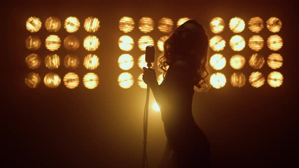 Silhouette Woman Singer Moving Seductively in Studio