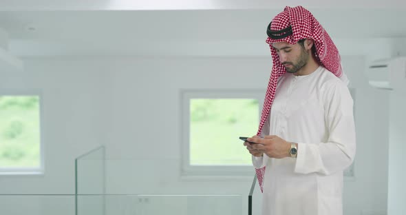 Arabian Businessman Wearing Traditional Clothes While Using Smartphone