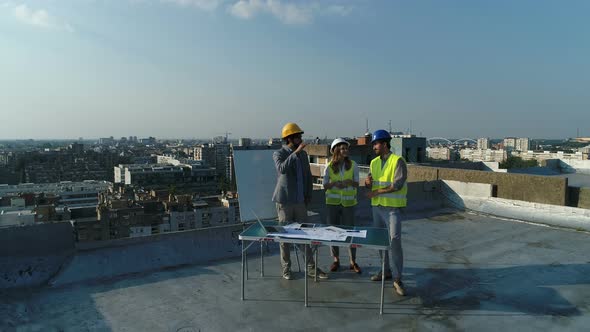 Team of Architects People in Group on Construction Site Check Documents