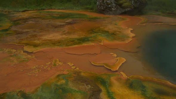 iceland landscape, geothermal hotspring steam smoke, body of water called orange pool, camera pan fr