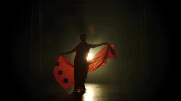 Silhouette a Young Girl Dancer in a Red Sari. Indian Folk Dance. Shot in a Dark Studio with Smoke