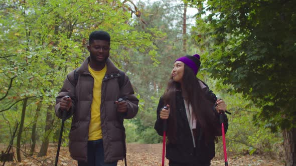 Diverse Couple Backpackers Hiking on Forest Path