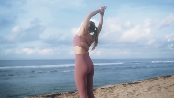 Woman Makes Fitness Workout on Beach at Sunrise with View on Sea Slow Motion