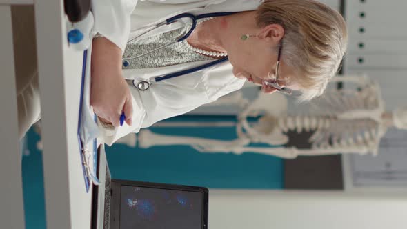 Vertical Video Female Medic Looking at Coronavirus Illustration on Laptop