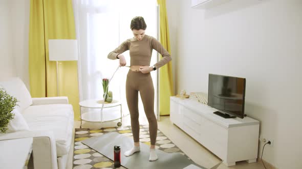 A Sporty Woman is Taking Measurements of Her Waist