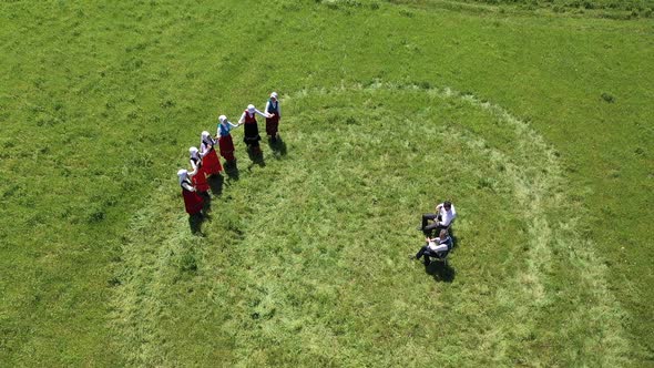 Young Women Traditionally Dancing In Traditional Clothes And Musicians