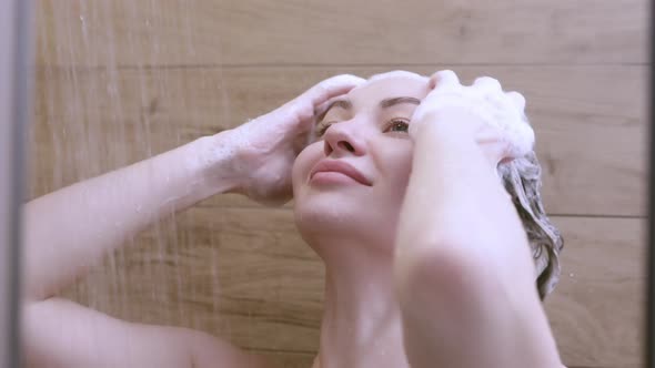 Beautiful Naked Young Woman Washes Her Hair and Uses Shampoo While Taking a Shower in the Bathroom