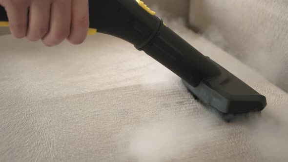 Hand Cleaning a Sofa with Steam Cleaner Home Cleaning Concept