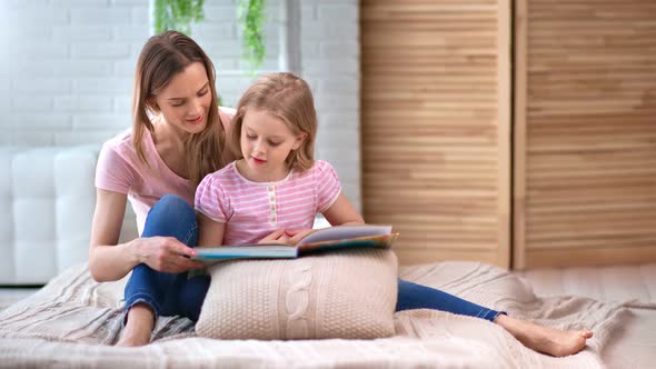 Domestic Happy Family Mother and Daughter Reading Book Together