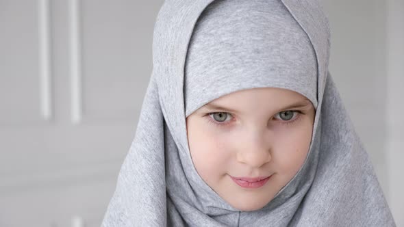 Young Muslim Teen Girl in Hijab Shyly Looking at Camera and Smiling