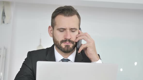 Businessman Talking on Phone with Customer