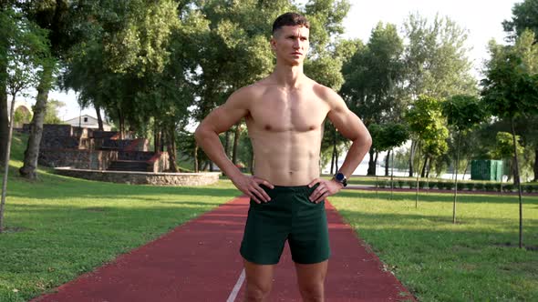 Serious Strong Guy Athlete with Bare Muscular Torso Looking at Sun Before Workout Achievement