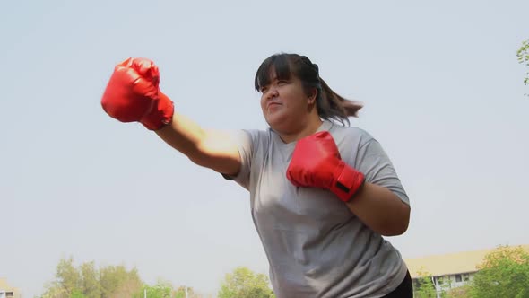 Happy overweight Asian woman wears Red boxing gloves Try to lose weight by exercise