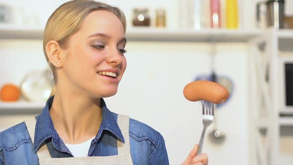 Cheerful Girl Biting Cucumber, Choosing Between Vegetable and Sausage, Vitamins