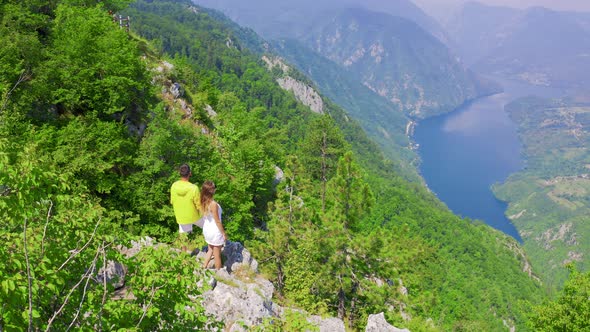 Aerial View on Couple Standing Against Amazing Nature View on Mountain Lake in on the Border of