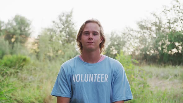 Caucasian man smiling and looking at camera during river clean-up day