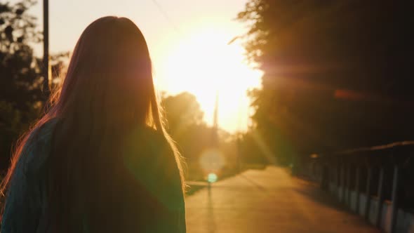 Silhouette of a Child Walking Down an Alley Flooded with Sunlight