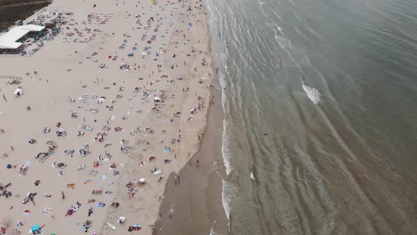 Aerial footage tilt revealing a coastline beach of Zandoort, Netherlands along the North Sea 4k