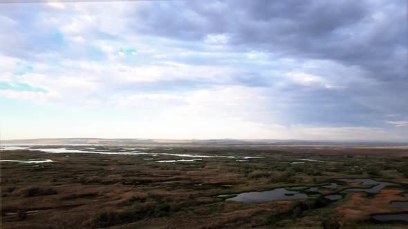 Many lakes dot sprawling marshlands reflect dark stormy skies, Potholes, Washington, aerial