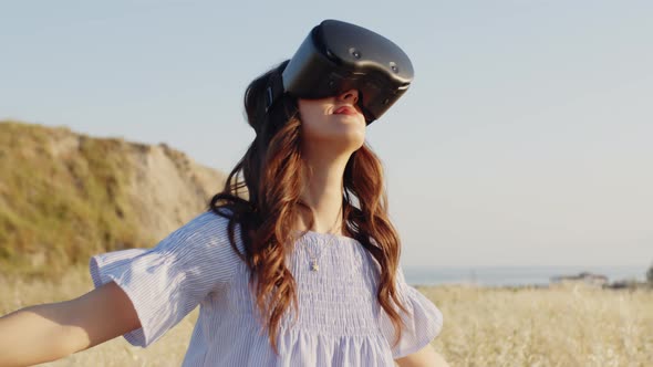 Girl with Virtual Reality Glasses in a Wheat Field in the Countryside